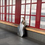 Cellist in Reflection by Red-Framed Windows Cellist with silver cello case by large red-framed windows in modern architectural space.