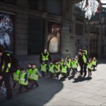Children on School Field Trip in Safety Vests Children on school field trip wearing safety vests walking near zoo animal advertisements.