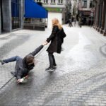 Playful Couple Sharing a Romantic Moment on City Street Playful couple on cobblestone street with rose in romantic urban city scene.