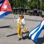 Cuban Flag Rally With Che Guevara Symbol in Public Square Cuban flag protest with Che Guevara in public square celebration.