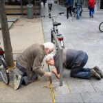Elderly Friends Sharing a Curious City Moment Two men examining something on ground.