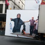 Evian Ad Truck with Delivery Man in City Scene Evian water truck advertisement with delivery man on urban city street.