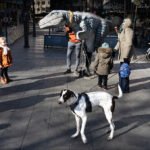 Children Playing With Dinosaur Street Performer in City Square Children interact with dinosaur street performer in lively city square.