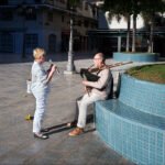 Bagpipe and Flute Performance in Sunny Plaza Bagpipe player and flutist performing music in sunny urban plaza.