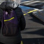 Stylish Purple and Black Backpack in Urban Setting Person wearing stylish purple and black backpack on urban street.