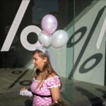 Pink Princess Dress and Balloons in City Celebration Woman in pink princess dress with balloons during urban celebration.