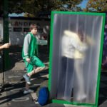 Colorful Urban Photo Booth With People Interacting Outdoors Urban street art photo booth with people interacting in vibrant outdoor city scene.