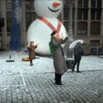 Festive Winter Celebration With Inflatable Snowman and Kids Children enjoying snowman celebration outdoors.