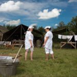 WW2 Nurses at Military Camp with Tents and Supplies WW2 nurses in white uniforms at military camp with tents and supplies.