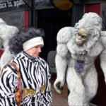 Woman Poses With Yeti Statues Outside Icebar in Spain Woman walking past yeti statues outside Icebar storefront in Spain.